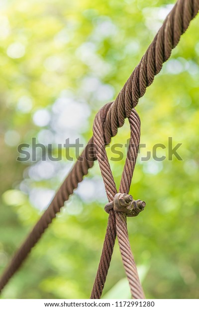 Steel wire rope lifeline on the bridge, Steel\
wire rope sling clip and has a large anchor suspension bridge with\
blurry background.