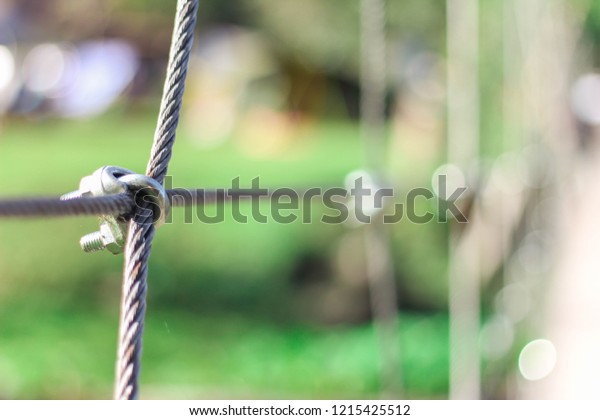 Steel wire rope lifeline on the bridge, Steel\
wire rope sling clip and has a large anchor suspension bridge with\
blurry background.