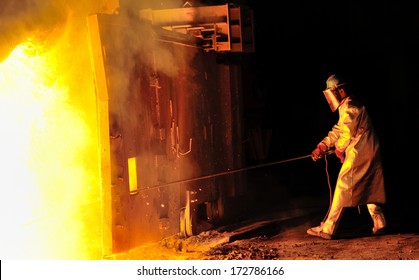 Steel Worker Takes A Sample From Oven