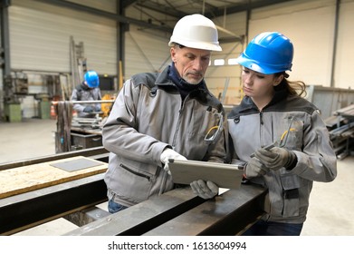 Steelwork Instructor With Young Apprentice In Workshop