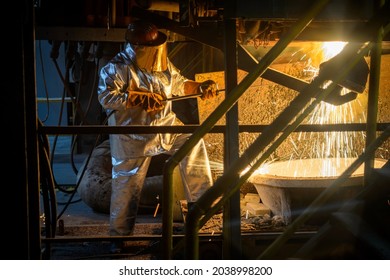 A Steelworker When Casting Draining Metal From A Cupola Furnace. Metallurgy.