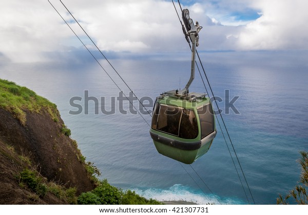 Steep cable car way\
from the mountain cliff to the ocean bay. Calhau das Achadas,\
Madeira island, Portugal.