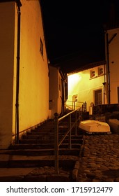 A Steep Flight Of Steps Leads Up Beside A Cobbled Street And An Upturned Boat In A Fishing Village At Night In Northern England.