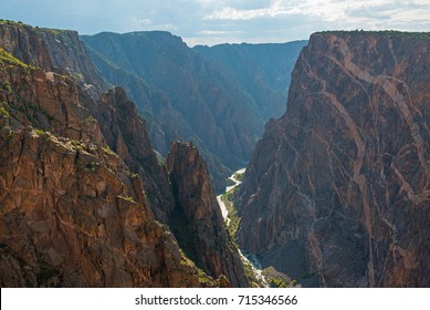 Steep granite cliffs of the Black Canyon of the Gunnison with the two dragons and the mysterious Gunnison River cutting through the rock in the valley, Colorado, USA.