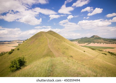 steep grassy mountain-ridge with a touristic pathway leading to the top