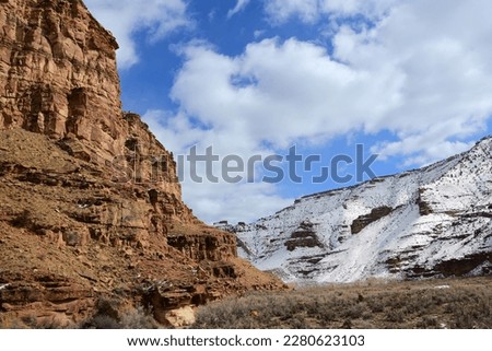 steep sandstone cliffs and snow- covered hillside on a sunny winter day  near  the ancient native american owl panel petroplyphs   in nine mile canyon, near wellington, utah