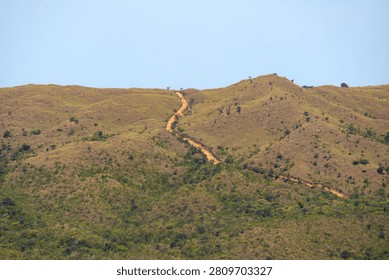 Steep Unpaved Access Path Cutting Through Grassy Mountain Terrain