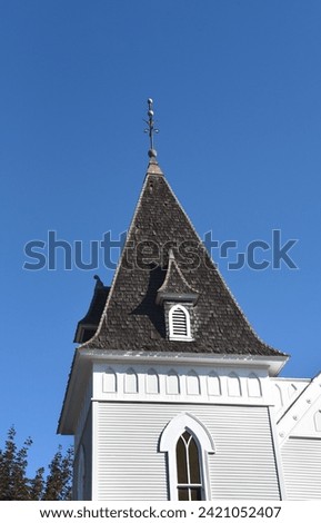 Steeple of the historic, First Presbyterian Church in Redmond, Oregon has wooden shakes for shingles.  Steeple is topped with finial.