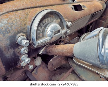 The steering column extends from underneath the odometer and dashboard on an old, rusting car in a junkyard near the small town of Vader, Washington.