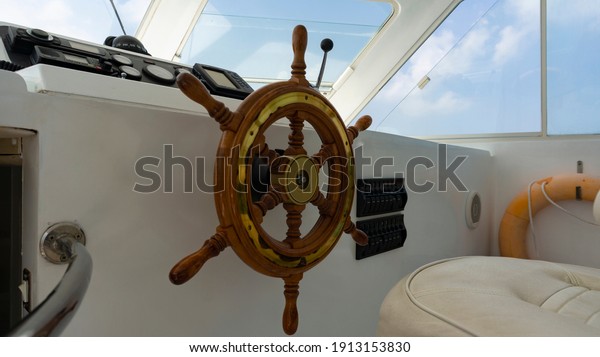 The steering wheel is in the cockpit of the\
yacht captain.