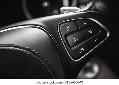 Steering wheel controls button inside luxury car with leather interior. Modern vehicle background 