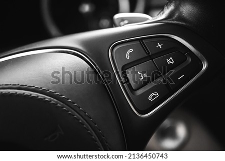 Steering wheel controls button inside luxury car with leather interior. Modern vehicle background 