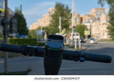 The steering wheel of an electric scooter standing on a city street. Close-up - Powered by Shutterstock