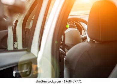 Steering Wheel And Empty Driver's Seat Of New Premium Suv Car Seen From The Rear Door. Selective Focus. Driver Seat In Sun Shine