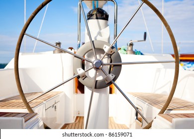 A steering wheel on a boat with empty seats/ Steering wheel on boat