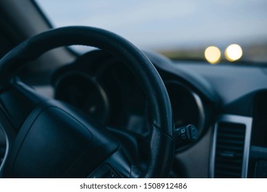 Steering Wheel. Oncoming Headlights. Sunset. Summer. Travelling By Car.