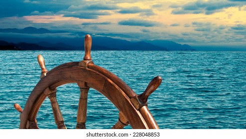 Steering Wheel At Sea Background.  Skipper's Wheel On An Old Ship. Sea Voyage At The Seaside With Captains Wheel Of The Old Vessel, Closeup.