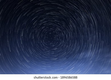 Stellar Trails, The Rotation Of Bright Stars At Night Around The Polar Star Against A Blue Sky