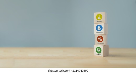 STEM concept. Science, technology, engineering, mathematics education. Education trend to solve a problems for innovation, high value product.  Wooden cubes with colorful STEM icons on grey background
