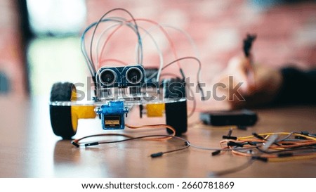 STEM Education Classroom With Obstacle Avoiding Robot Programming on Table. A Back to School Learning Session Featuring Hands-On Robotics, Wiring, and Microchip Circuits by Young Students.