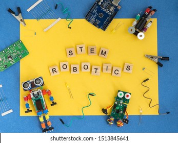 STEM school concept. A metal robot and an electronic board that can be programmed. Robotics and electronics. DIY robotics. STEM education for kids. Flat lay. Free space for text.