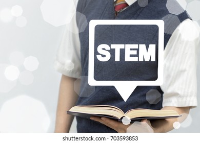 STEM - Science Technology Engineering Mathematics Concept. Student (learner Or Scientist) Holds Book With Stem Speech Bubble On A Virtual Screen.