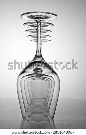 Stemware reflecting and repeating, forming a pattern of abstract shapes in black and white
