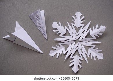 Stencil for cutting out snowflakes and a snowflake from paper on the table - Powered by Shutterstock - Get 15% off with code: PIKWIZARD15