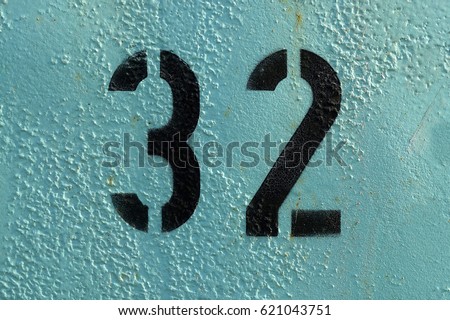stencil number 32, black spray paint on light blue background