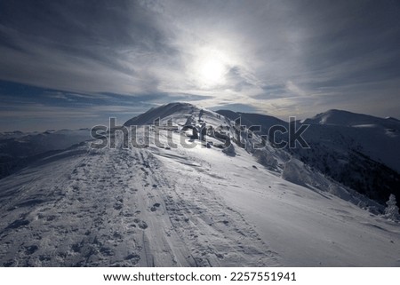Steny, Mala Fatra, Slovakia - touristic track, trail, footpath and pathway on the mountain ridge. Landscape in the winter and wintertime. Evening backlight and nature covered by snow. Heavy vignetting