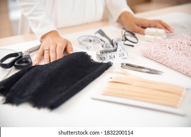Step 1 process of sewing underwear and clothes, woman tailor cuts blanks for panties from black lace.