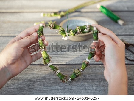 Step 4. Make a heart shape from dandelions garland. Creative crafts with natural material. Simple DIY concept.	