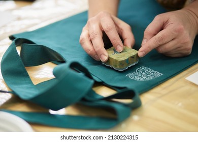 Step 5. Press the seal to the fabric in the right place and tap on the stamp. selective focus - Shutterstock ID 2130224315