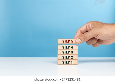 Step, begin, important start, method and step process concept. Hand arrange the wooden blocks of step 1 to 5 indicating task priority and management