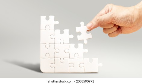 Step By Step To Build Up Future With Your Own Hands Concept, Hand Fill White Jigsaw Puzzle To Fulfill The Puzzle