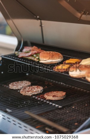 Step by step. Cooking burgers on outdoor gas grill in the Summer.