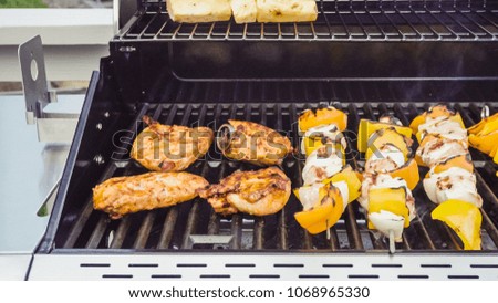 Step by step. Cooking chicken shish kabobs with bell peppers and yellow onions on outdoor gas grill.