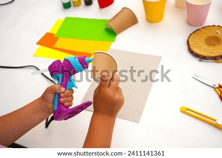 Step by step diy process. Point 3 Glue the halves of the glass onto the cardboard. Kids craft giraffe from a paper coffee cup, zero waste concept.