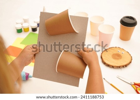 Step by step diy process. Point 3 Glue the halves of the glass onto the cardboard. Kids craft giraffe from a paper coffee cup, zero waste concept.