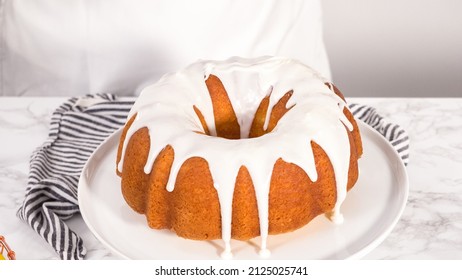 Step by step. Glazing a lemon bundt cake with white glaze on a cake stand.