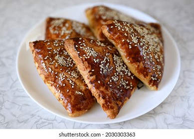 Step By Step Instructions. Step Ten. How To Make A Puff Pastry Product With Meat At Home. Ready-made Homemade Puff Pastry Sprinkled With Sesame Seeds With Meat Filling On A Plate.