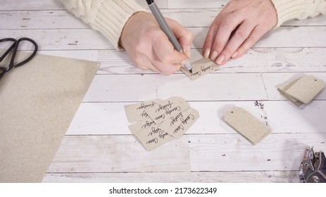 Step By Step. Labeling Brown Paper Gift Tags With A Black Marker.