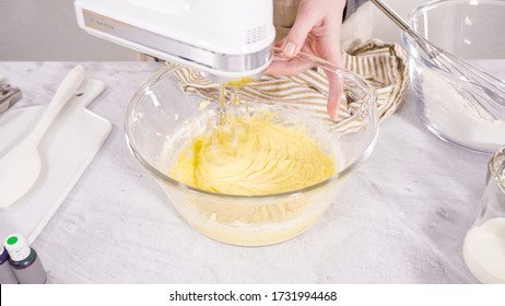 Step by step. Mixing ingredient in a mixing bowl with an electric mixer to bake vanilla Mardi Gras cupcakes. - Powered by Shutterstock