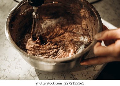 Proceso paso a paso de hacer muffins de chocolate, bizcochos. Golpear a la masa con cacao en un recipiente para mezclar. Concepto de hormigón.