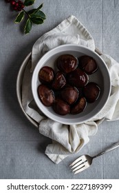 Step by step process of making oven-roasted chestnuts. Chestnuts soaked in water before roasting.
