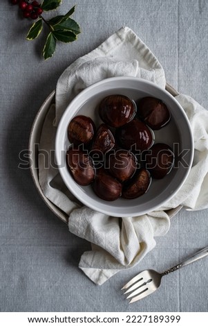 Step by step process of making oven-roasted chestnuts. Chestnuts soaked in water before roasting.