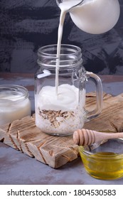 Step By Step Recipe Of The Overnight Oats. Milk Is Poured Into The Glass Jar With The Ingredients