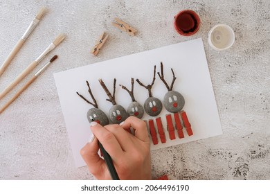 Step By Step. Top View. Process Kid Children Craft. Do It Yourself Diy Merry Christmas Deer On Greeting Card Postcard Made Of Pebbles, Sea Stones, Clothespins And Branches On White Background. Natural