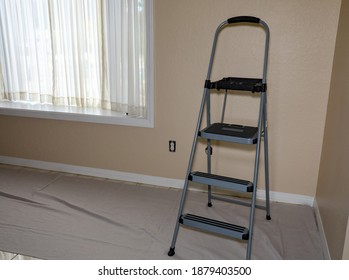 A Step Ladder On Top Of A Drop Cloth Inside A House.