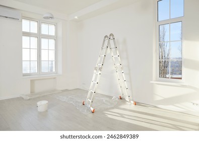 Step ladder, paint bucket and piece of floor protective film in corner of modern living room with freshly painted white walls, plastic windows and no people. Home renovation, apartment renewal concept - Powered by Shutterstock